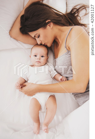 Top view. Happy Young Mother with Baby in Bed. Top view. Happy Young Mother with Baby in Bed. 42001127