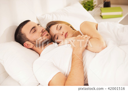 Young Happy Couple Lies in White Bed and Sleep. Young Happy Couple Lies in White Bed and Sleep. 42001516