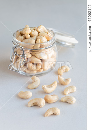 Cashew nuts in glass jar on concrete background Cashew nuts in glass jar on concrete background 42002143