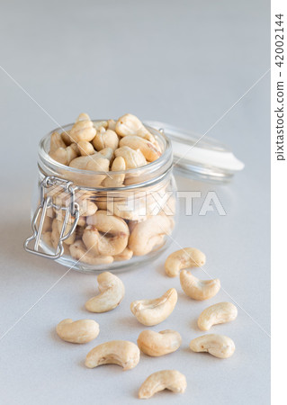 Cashew nuts in glass jar on concrete background Cashew nuts in glass jar on concrete background 42002144