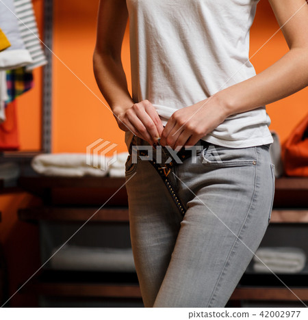 Young woman chooses clothes in wardrobe. 42002977