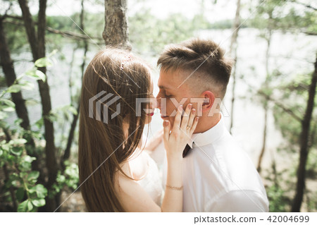 Wedding couple man, bride kissing and hugging on a background of the river, mountains. Beauty 42004699