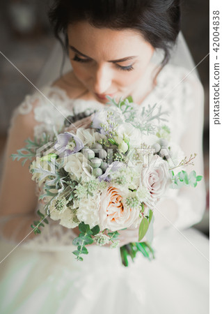 Beautiful bride wearing fashion wedding dress with feathers with luxury delight make-up and Beautiful bride wearing fashion wedding dress with feathers with luxury delight make-up and 42004838