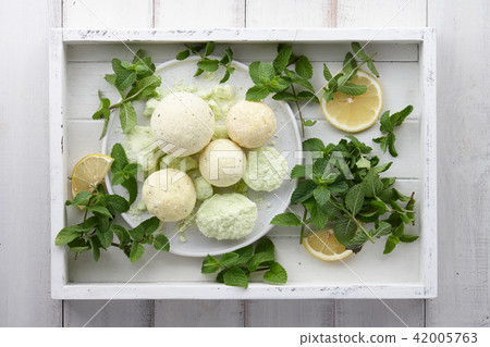 Handmade mint bath bombs with fresh herbs in white tray Handmade mint bath bombs with fresh herbs in white tray 42005763