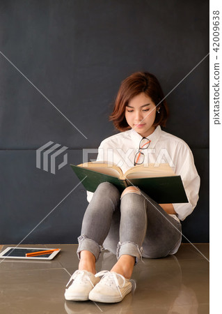 Pretty asian girl reading a book. 42009638