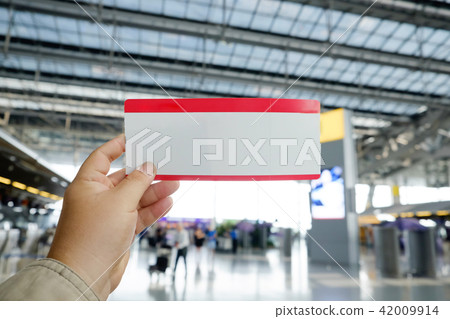 Hands holding an air ticket in airport terminal. Hands holding an air ticket in airport terminal. 42009914