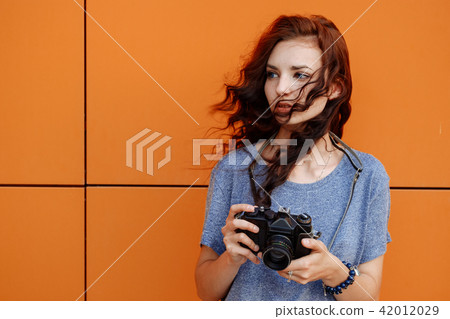Portrait of a beautiful girl using a vintage film 35mm camera 42012029