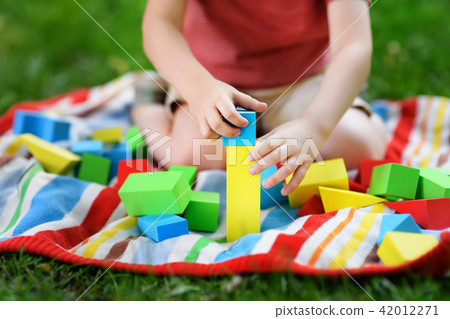 Cute preschooler boy playing with colorful cubes Cute preschooler boy playing with colorful cubes 42012271