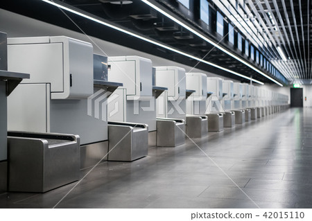 Interior of check-in area in modern airport: luggage accept terminals with baggage handling belt 42015110