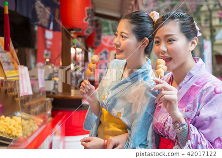 ladies eating the fried meat balls ladies eating the fried meat balls 42017122
