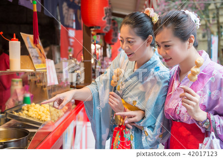 ladies eating the fried meat balls beside street ladies eating the fried meat balls beside street 42017123