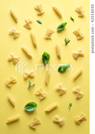 various pasta on yellow background 42018030