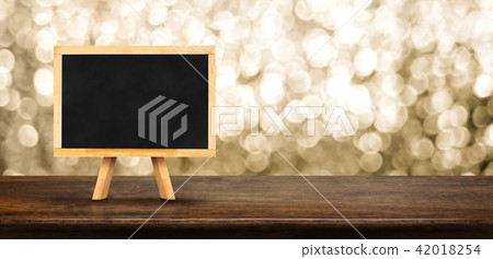 Blank blackboard on wood table with blur sparkle 42018254