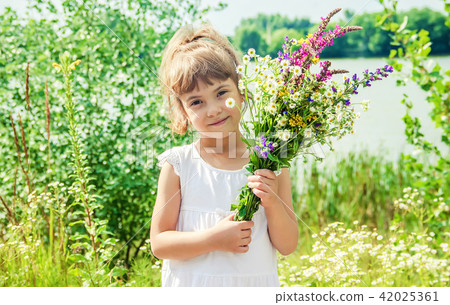Child with a bouquet of wildflowers. Selective focus. Child with a bouquet of wildflowers. Selective focus. 42025361