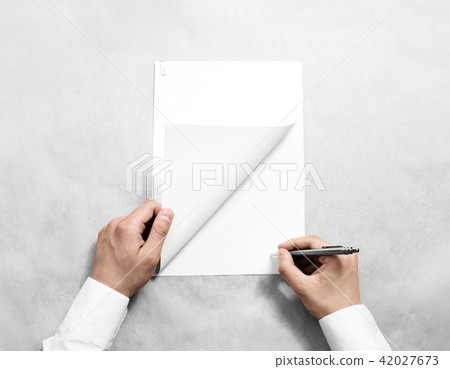 Hand holding blank agreement mockup and signing it Hand holding blank agreement mockup and signing it 42027673