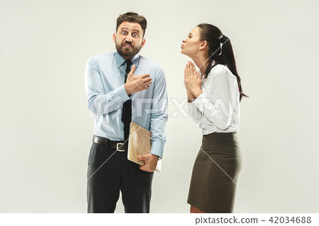 Angry boss. Man and his secretary standing at office or studio Angry boss. Man and his secretary standing at office or studio 42034688