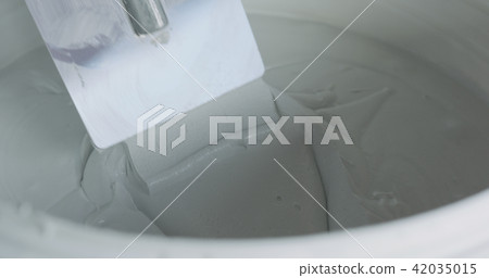 closeup worker dipping the trowel into the decorative concrete plaster 42035015