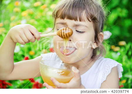 The child eats honey. Selective focus. nature. 42039774