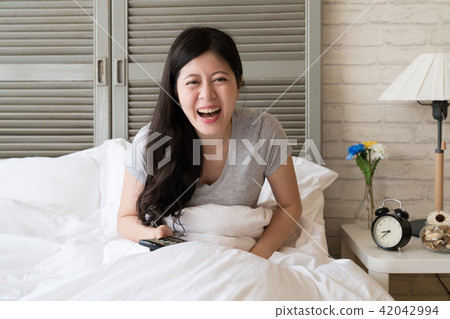 woman watching and pointing the TV woman watching and pointing the TV 42042994