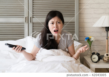 woman sitting in the bed and shrugged woman sitting in the bed and shrugged 42043005