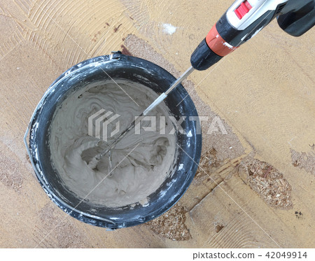 Man is mixing grey concrete and prime 42049914