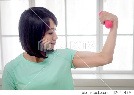Young girl lifting dumbbells Young girl lifting dumbbells 42051439