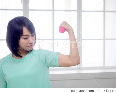 Young girl lifting dumbbells Young girl lifting dumbbells 42051453