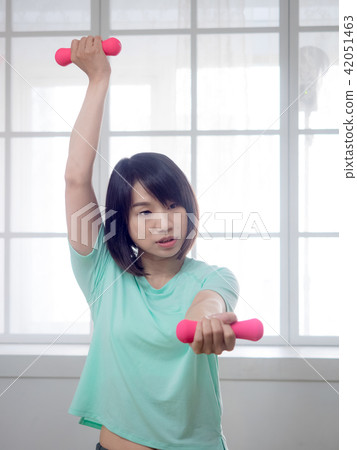 Young girl lifting dumbbells Young girl lifting dumbbells 42051463