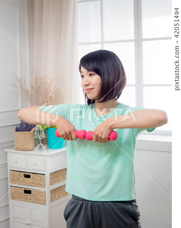 Young girl lifting dumbbells Young girl lifting dumbbells 42051494