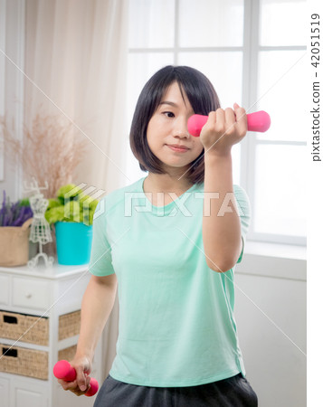 Young girl lifting dumbbells Young girl lifting dumbbells 42051519
