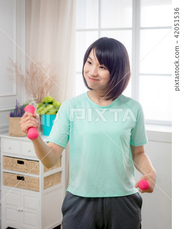 Young girl lifting dumbbells  42051536