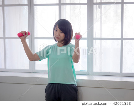 Young girl lifting dumbbells Young girl lifting dumbbells 42051538