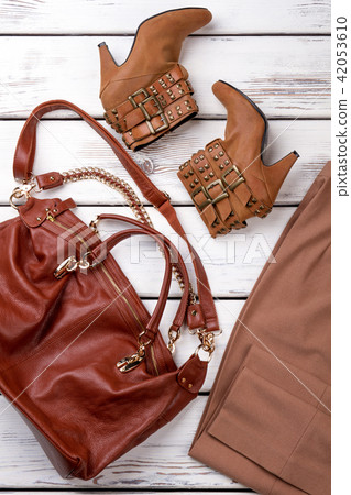 Brown woman's purse with heel boots and pants. Brown woman's purse with heel boots and pants. 42053610