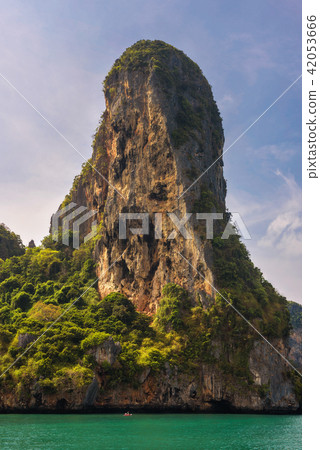 Small boat under huge cliff of Phi Phi islands Small boat under huge cliff of Phi Phi islands 42053666