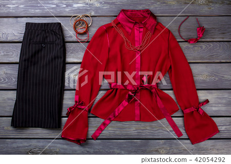 Black trousers and red blouse, flat lay. 42054292