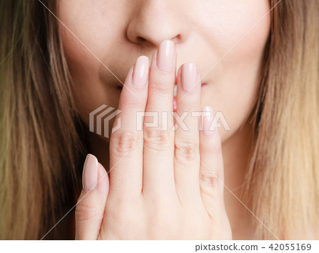 Part of face woman covering her mouth with hand 42055169