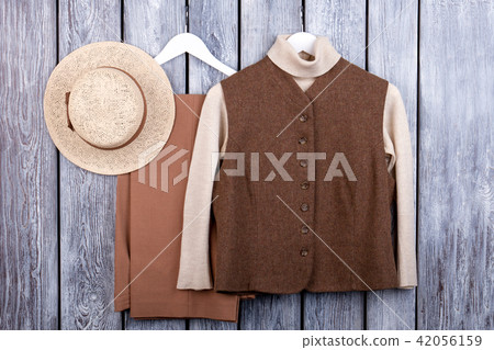Flat lay, brown vest, trosuers and straw hat. 42056159