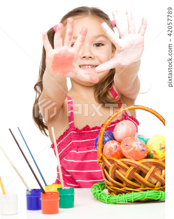 Little girl is painting eggs preparing for Easter 42057789
