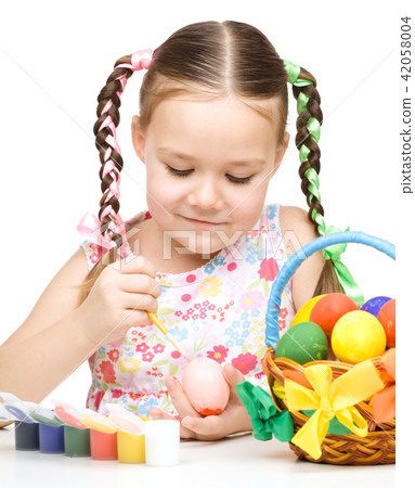 Little girl is painting eggs preparing for Easter 42058004