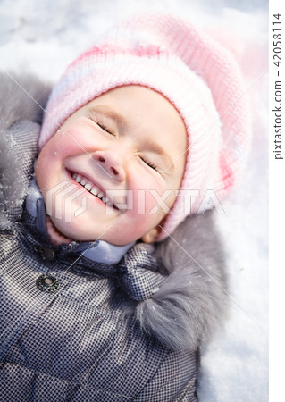 Little girl is laying on a snow 42058114