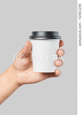 Mockup of men's hand holding white paper small size cup with black cover 42061299