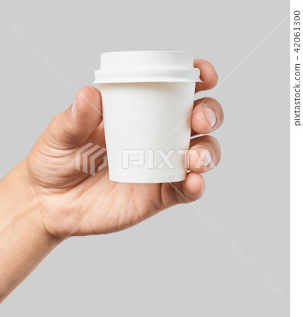 Mockup of men's hand holding white paper espresso cup with white cover Mockup of men's hand holding white paper espresso cup with white cover 42061300