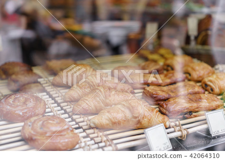 many of croissants. Hot pastries lie on the shelf in the cafe. Buns and bagels in the store. many of croissants. Hot pastries lie on the shelf in the cafe. Buns and bagels in the store. 42064310