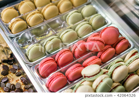 Assortment of colorful macaroons on cafe showcase. Variety of macaron flavours. Sweet almond cakes 42064326