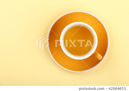 Yellow cup of green oolong tea on saucer 42064653