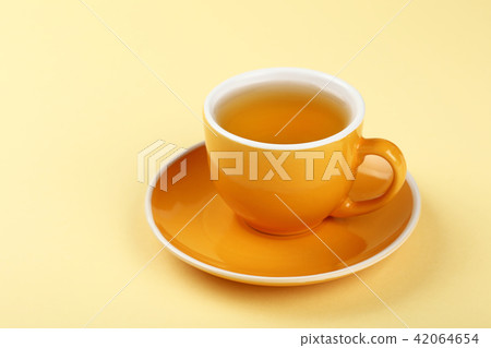 Yellow cup of green oolong tea on saucer 42064654