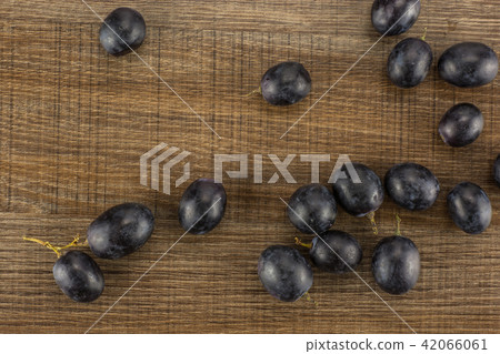 Fresh Black Wine Grapes on brown wood Fresh Black Wine Grapes on brown wood 42066061