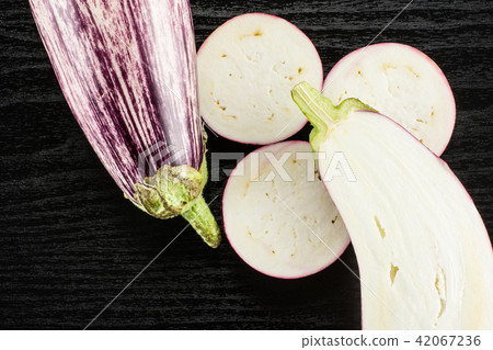 Fresh raw striped Eggplant on black wood Fresh raw striped Eggplant on black wood 42067236