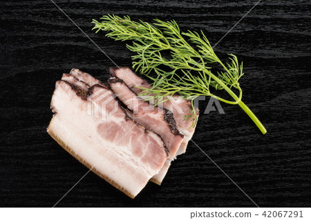 Fresh smoked english bacon on black wood 42067291