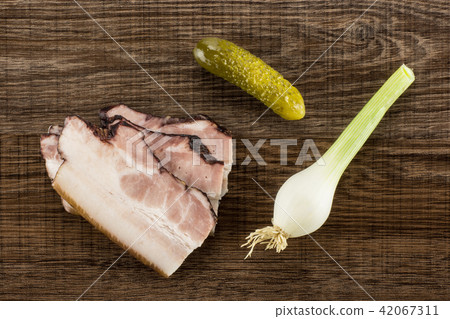 Fresh smoked english bacon on brown wood 42067311